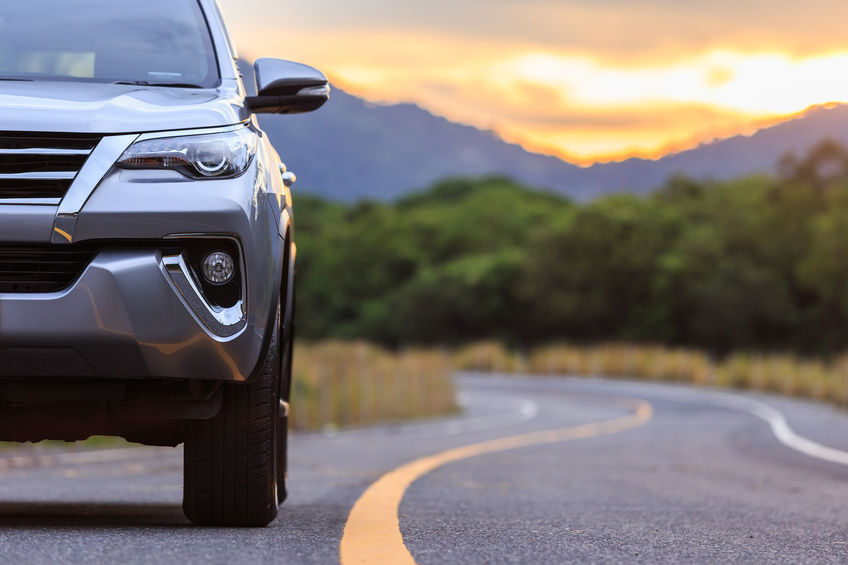 Close up of new silver SUV driving on road