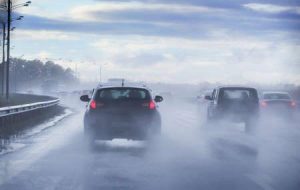 Cars navigate the highway in the rain.