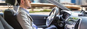 side view of a young man sitting inside autonomous car