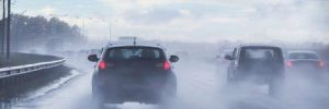 Cars navigate the highway in the rain.